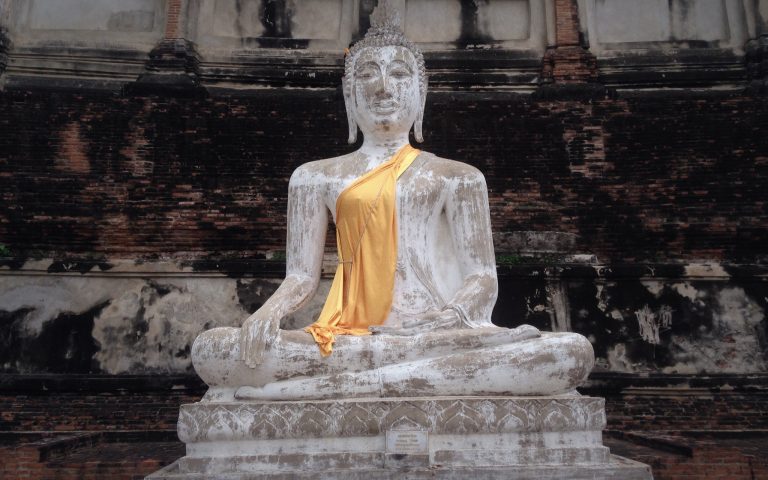 Будда на фоне древней стены